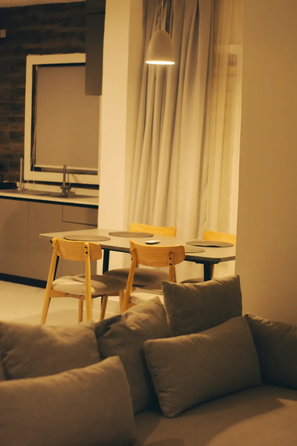 Comedor pequeño con mesa de madera y cuatro sillas junto al sofá