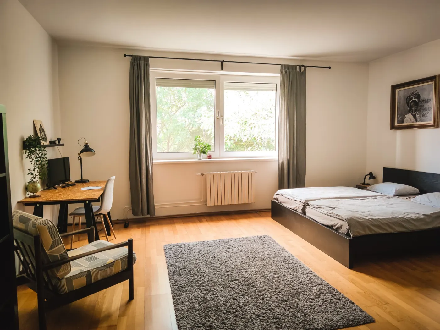 Estudio pequeño con cama, escritorio y una ventana grande